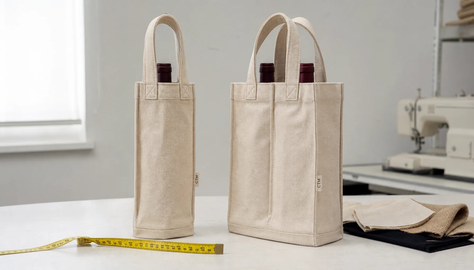 Natural canvas wine carriers with a sewn CTM CottonToMaker side label in a factory sample room