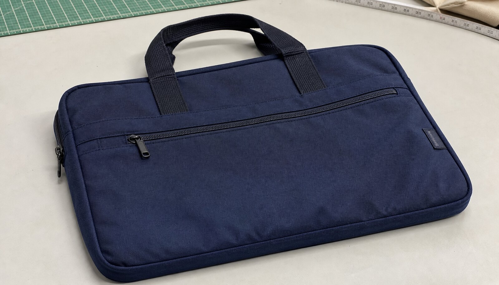 Zipper business document bag with a simple logo shown in a clean factory sample room