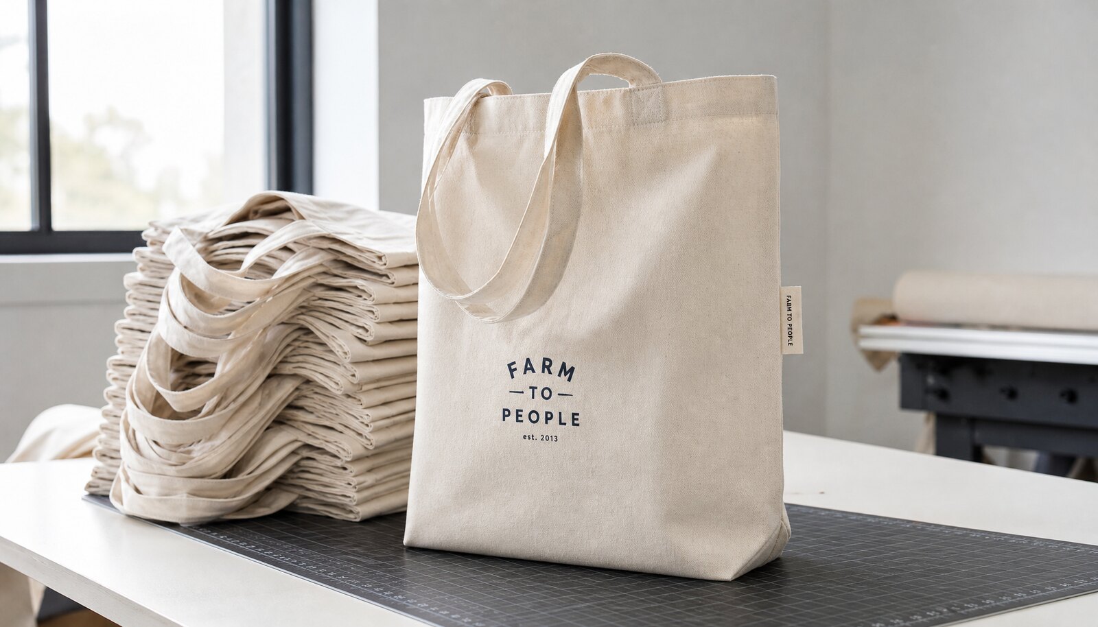Natural canvas grocery tote with a small CTM CottonToMaker label shown in a clean factory sample room