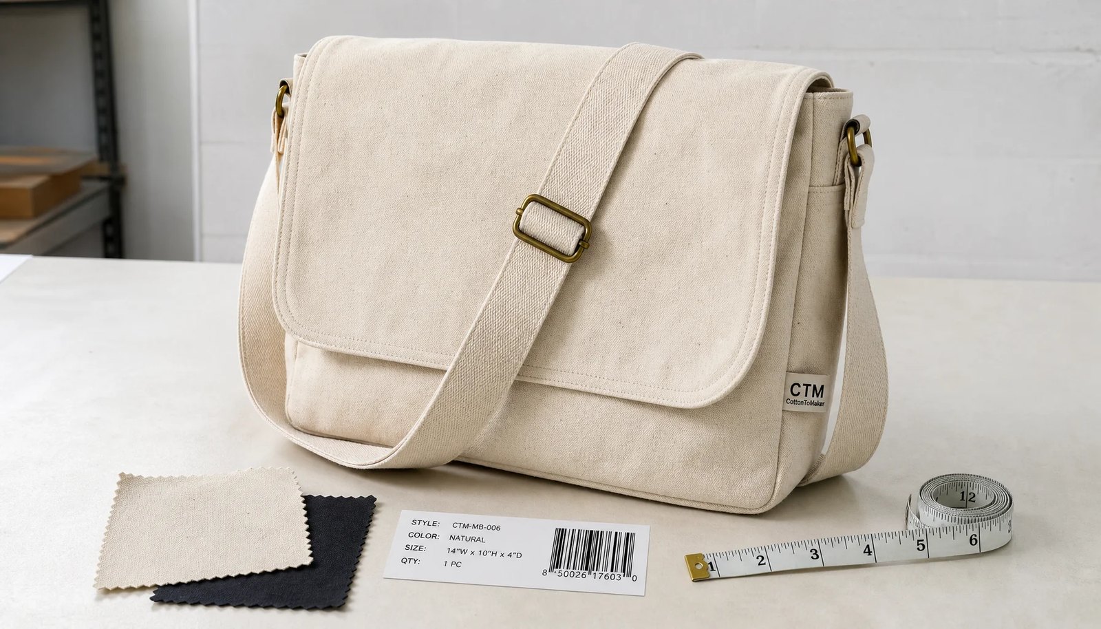 Natural canvas messenger bag with CTM CottonToMaker side label on a studio worktable