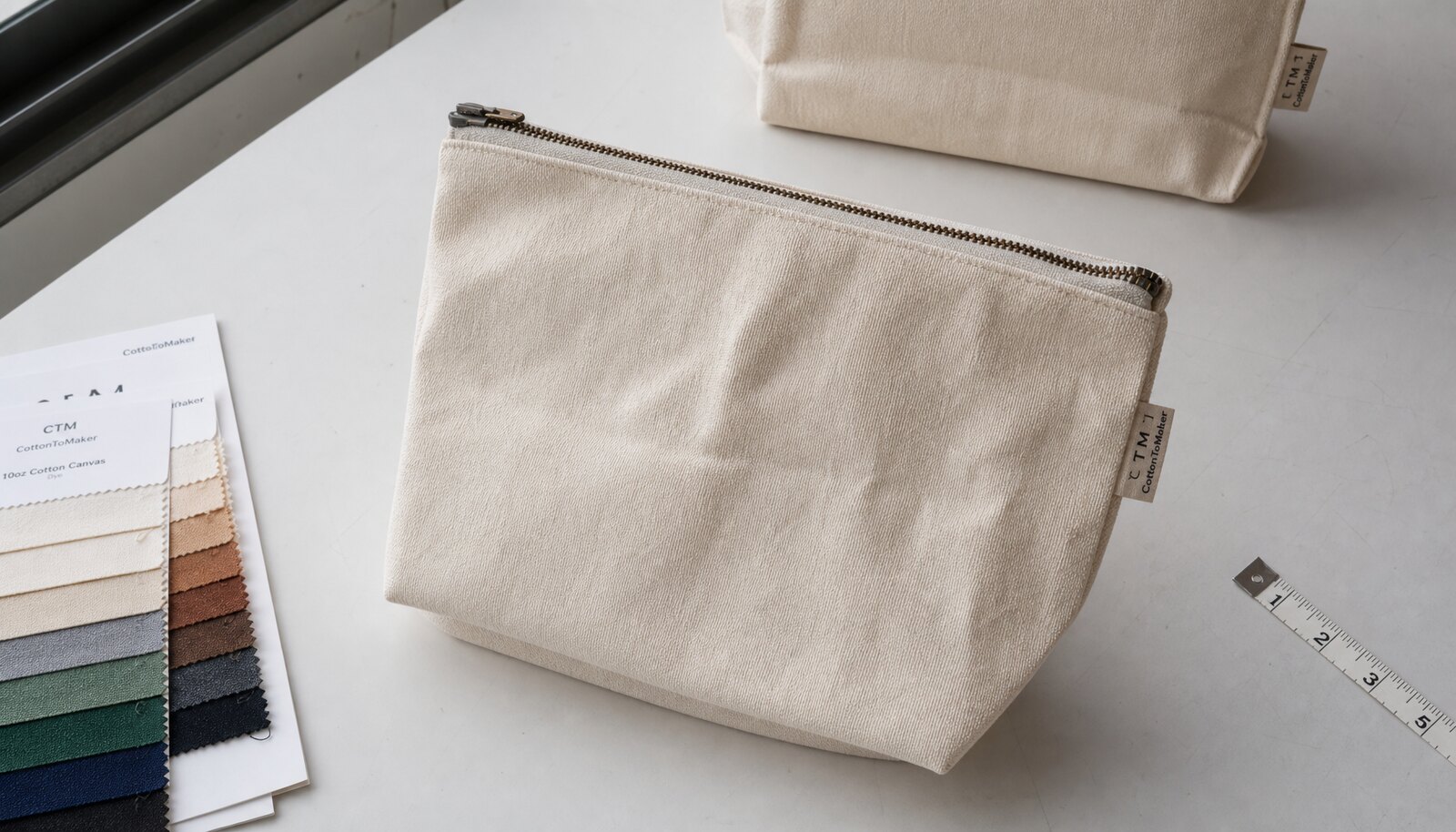 A natural canvas zipper bag with a small CTM side label shown in a clean factory sample room
