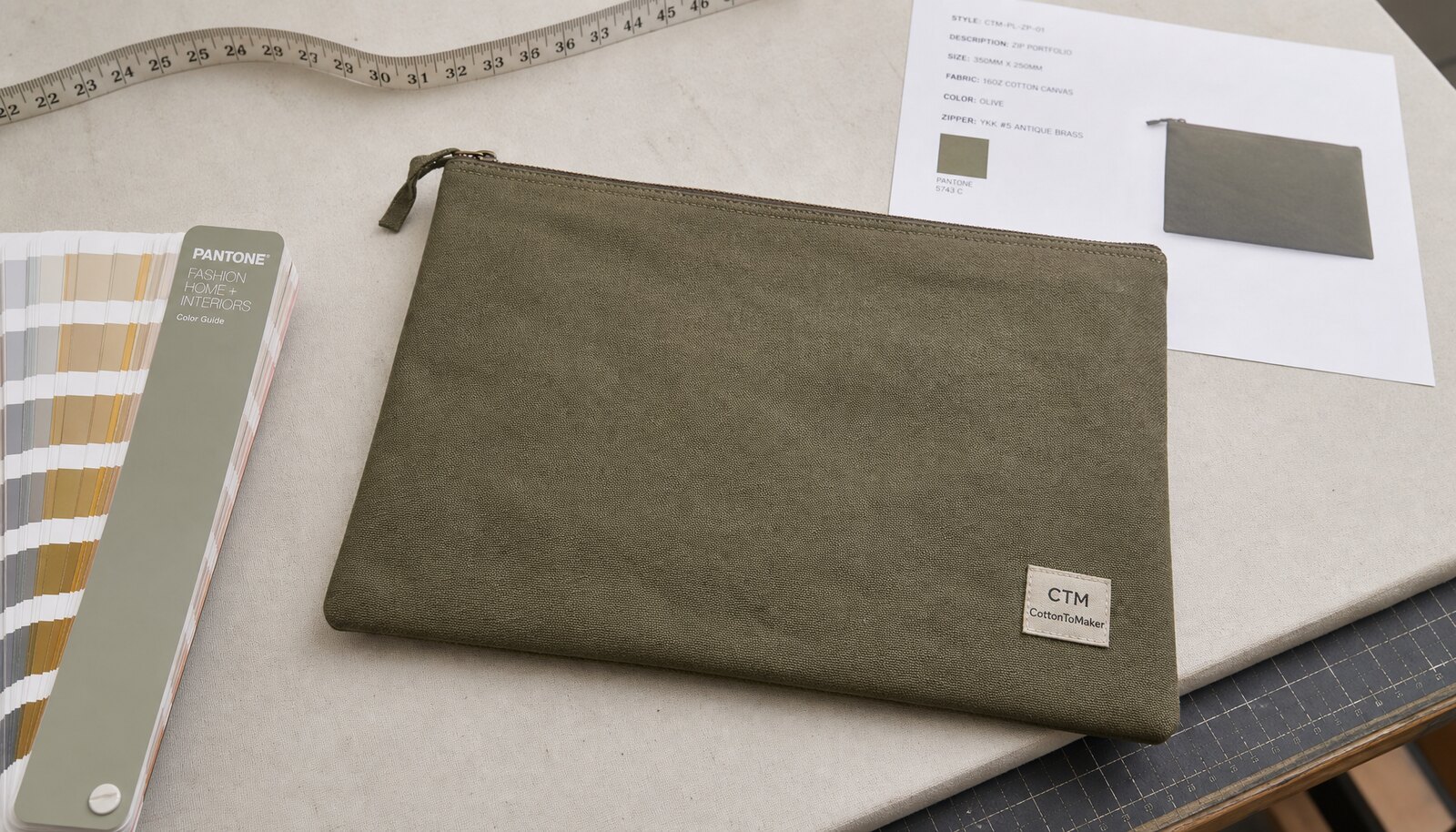 Canvas zipper portfolio with a small CTM sample logo, shown in a clean factory sample room for print proofing review.