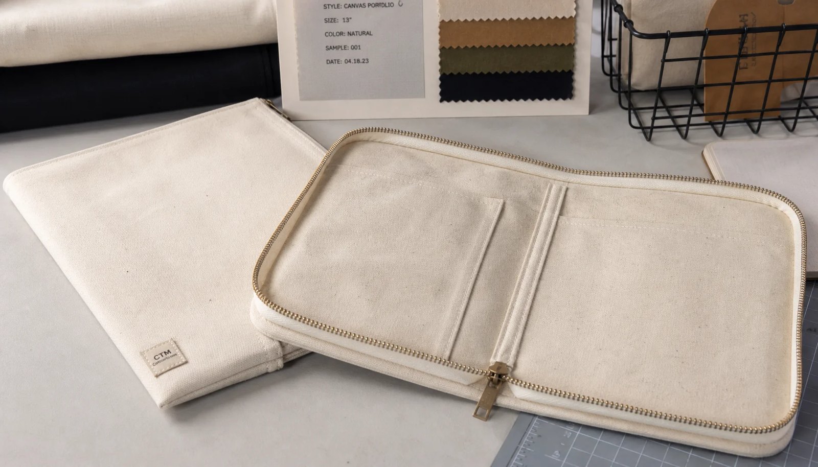 Photorealistic canvas zipper portfolio with a CTM/CottonToMaker woven side label in a factory sample room