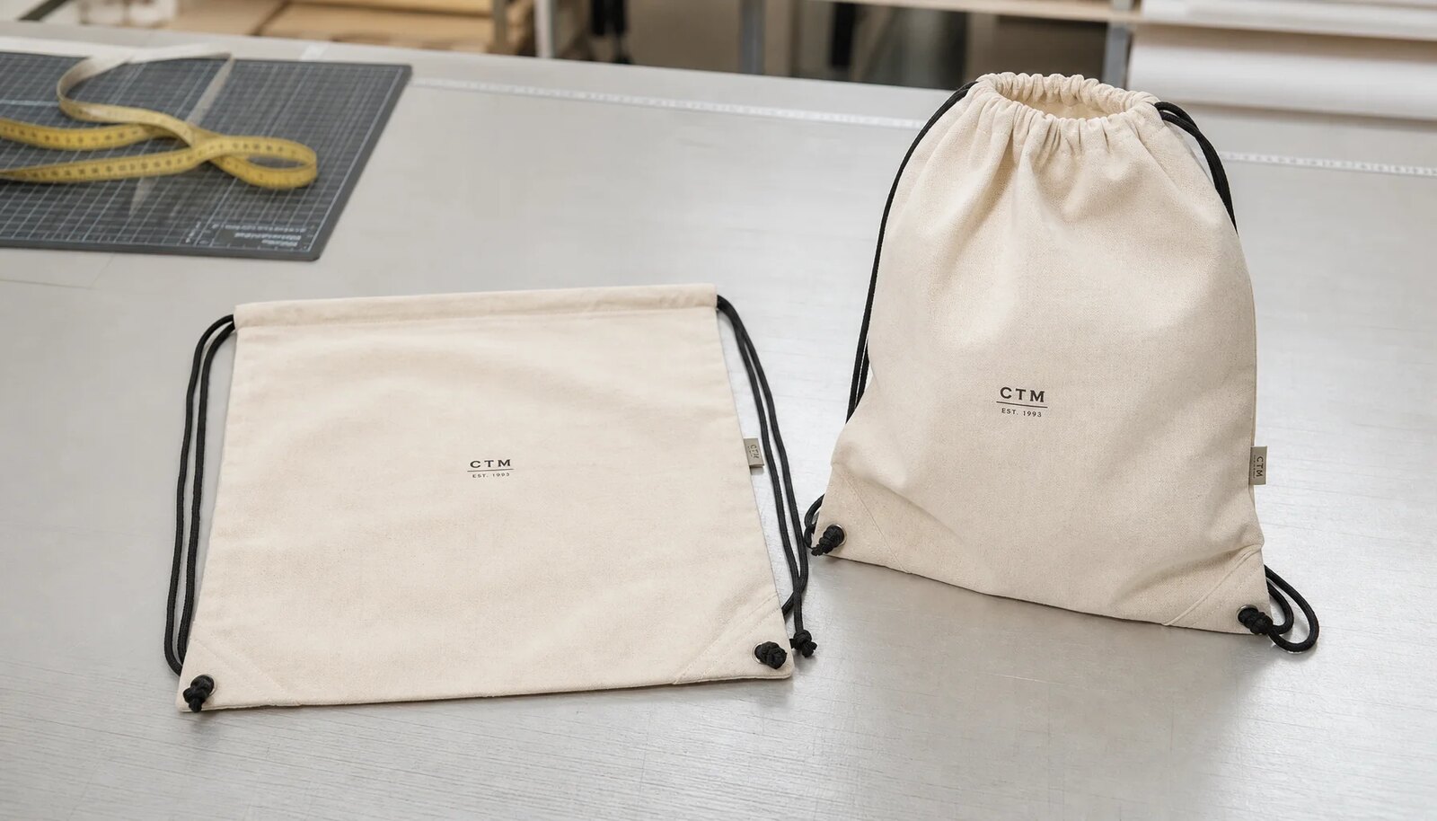 Natural cotton drawstring backpack sample with screen print logo and reinforced lower cord exits