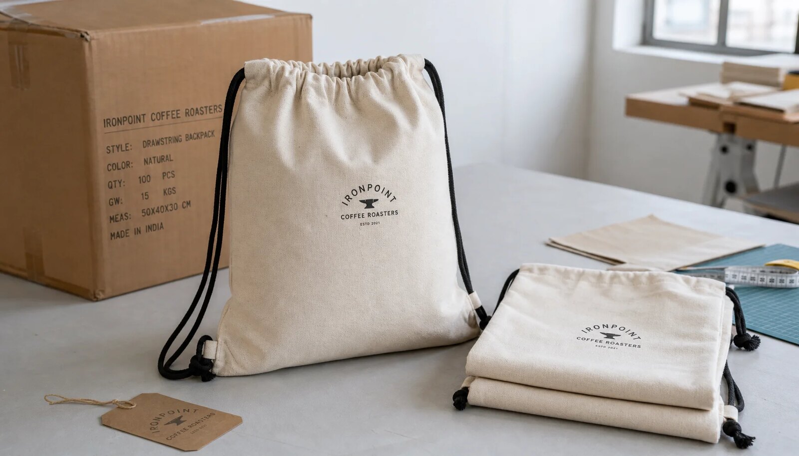 Natural cotton drawstring backpacks with a simple CTM printed logo in a factory sample room