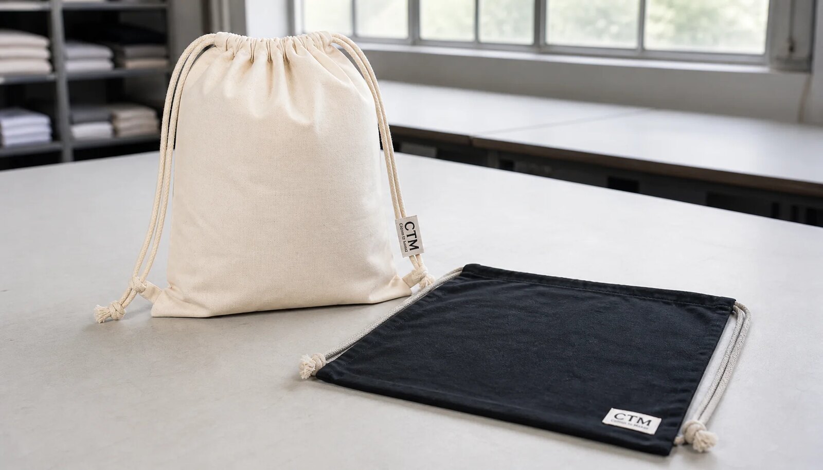 Cotton drawstring backpacks with a small CTM sample logo shown in a clean factory sample room