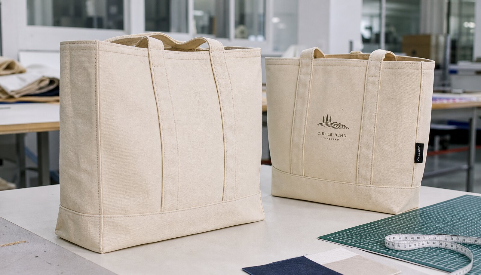 Custom canvas grocery totes with a small woven label and printed winery-style logo in a clean factory sample room