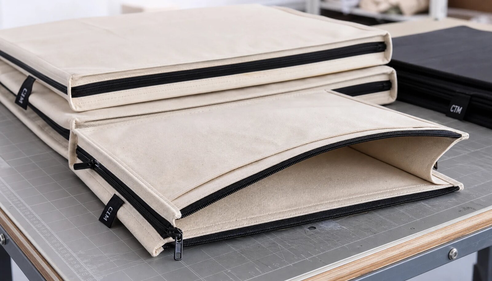 Custom canvas zipper portfolios with CTM woven side label stacked for craft fair shipping carton planning