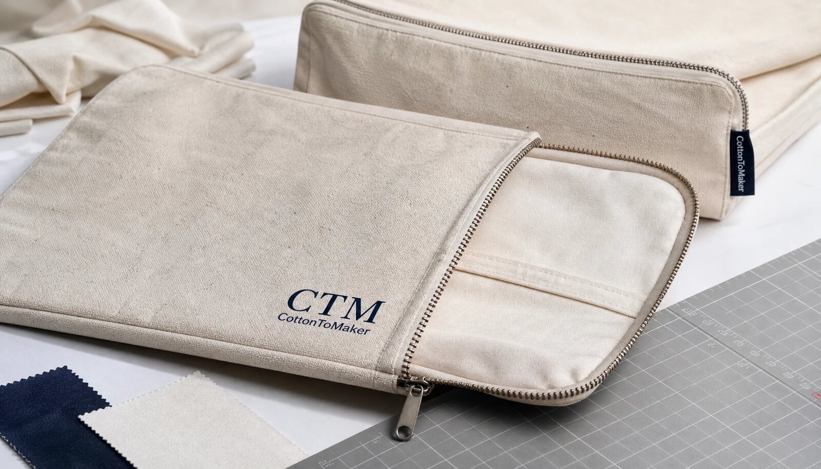 Custom canvas zipper portfolios with CTM sample logo on a clean studio table