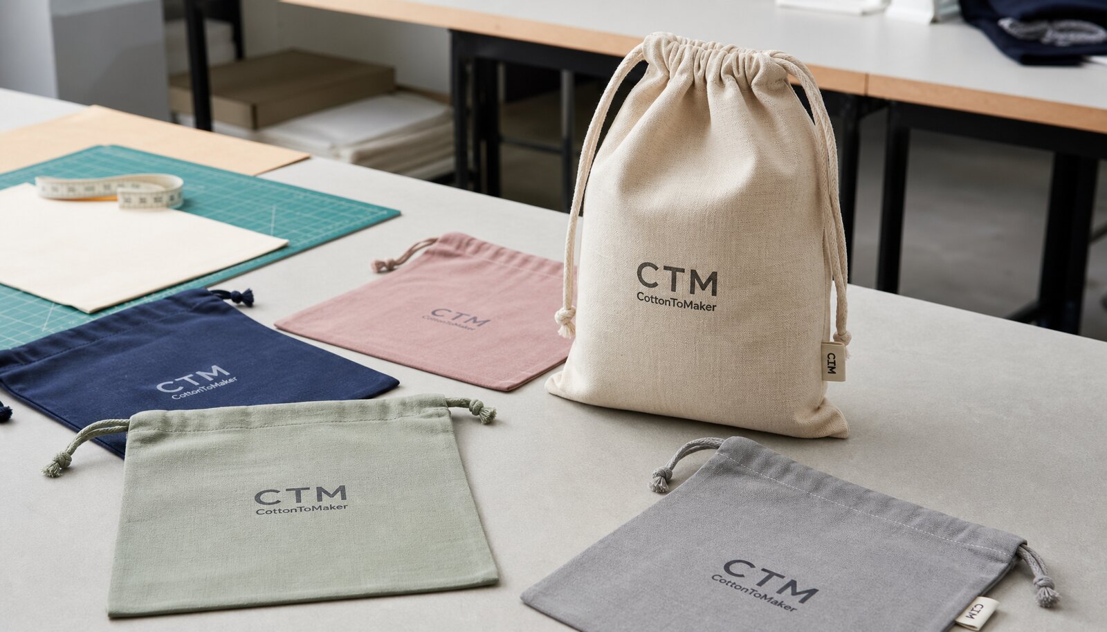 Custom printed drawstring bags with a CTM CottonToMaker sample logo displayed in a clean factory sample room.