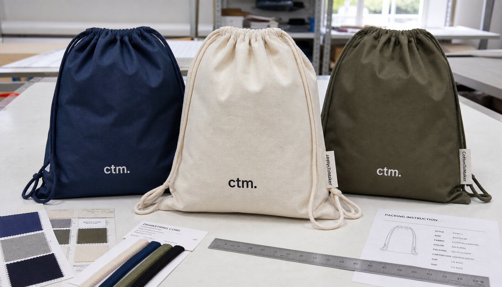 Drawstring backpack samples with CTM logo, fabric swatches, cords, and packing sheet in a factory sample room