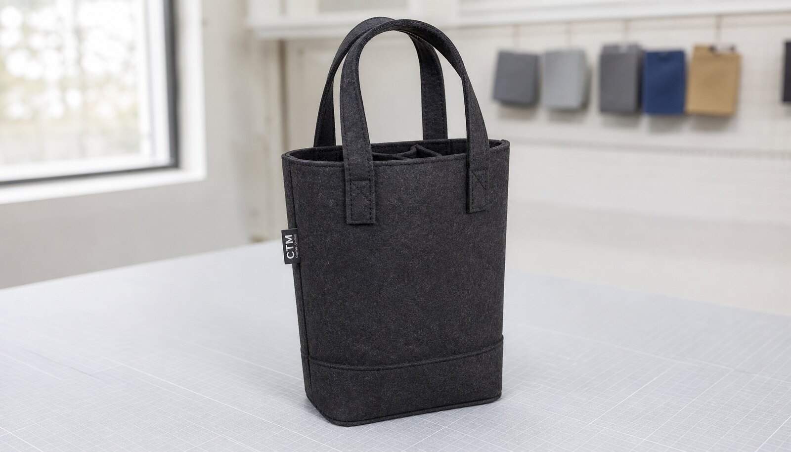 Photorealistic felt wine tote bag for hotel minibars with a small CTM side label in a clean sample room.
