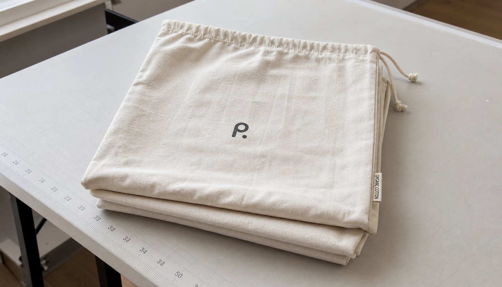 Organic cotton drawstring bags with a simple printed logo in a factory sample room