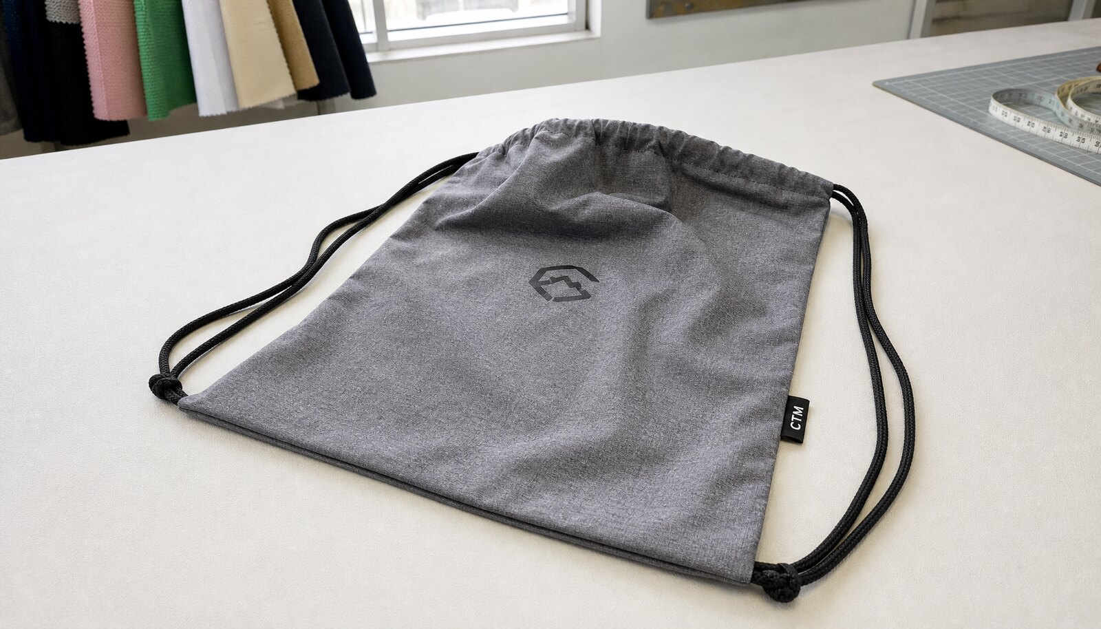 Photorealistic promotional drawstring sportpack with a CTM woven side label in a factory sample room