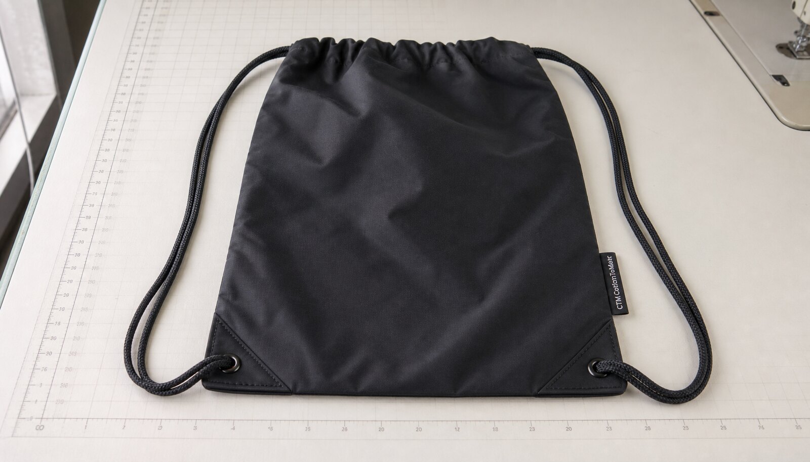 Photorealistic sports drawstring backpack with a CTM/CottonToMaker woven side label in a factory sample room