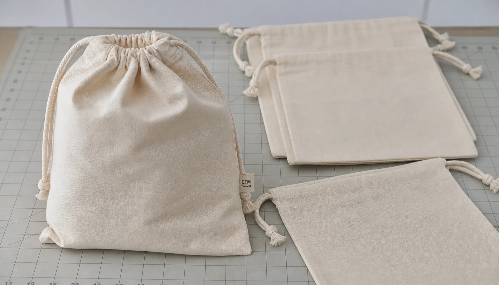 Photorealistic natural cotton drawstring pouch with a CTM side label in a clean sample room