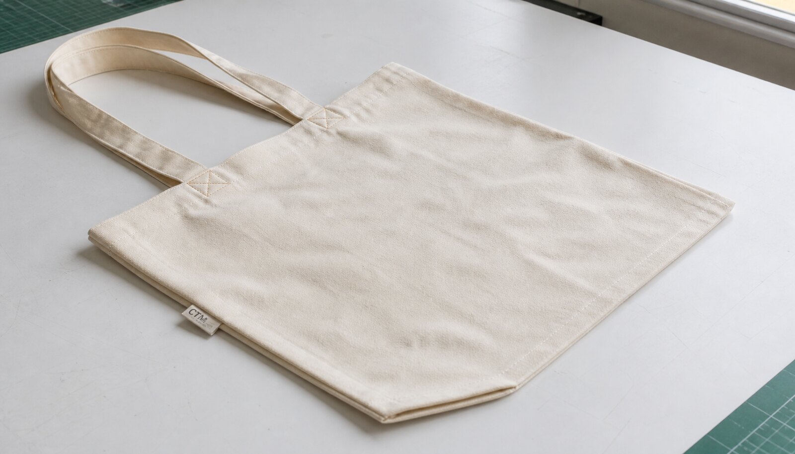 Organic cotton tote with a CTM CottonToMaker sample logo in a factory sample room