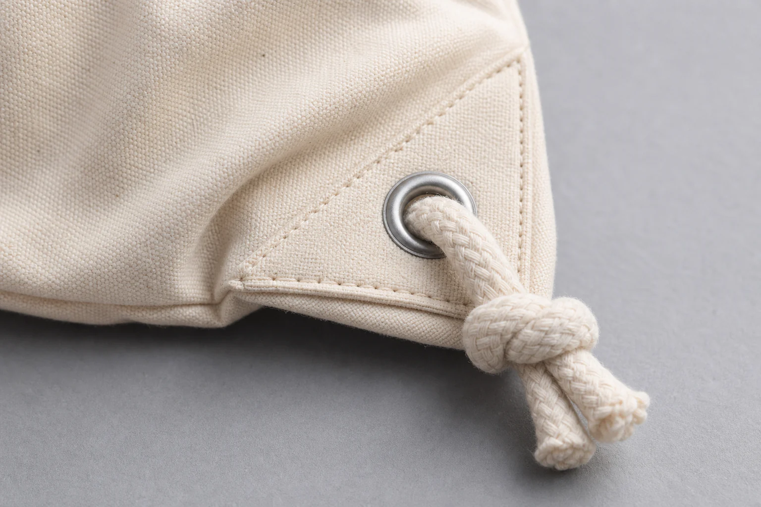 Reinforced corner grommet, rope routing, and knot detail
