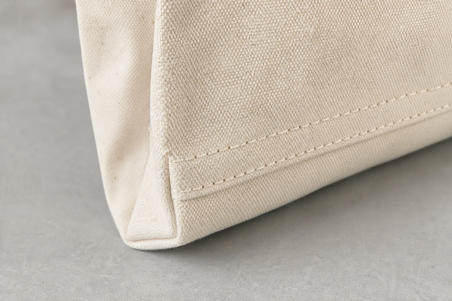 Heavy canvas weave, reinforced stitching, and handle attachment detail